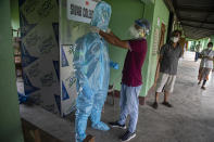 An Indian health worker helps another to wear personnel protection equipment kit before he collects nasal swab samples at a COVID-19 testing center in Gauhati, Assam state, India, Sunday, July 12, 2020. India is the world’s third worst-affected country by the coronavirus. (AP Photo/Anupam Nath)