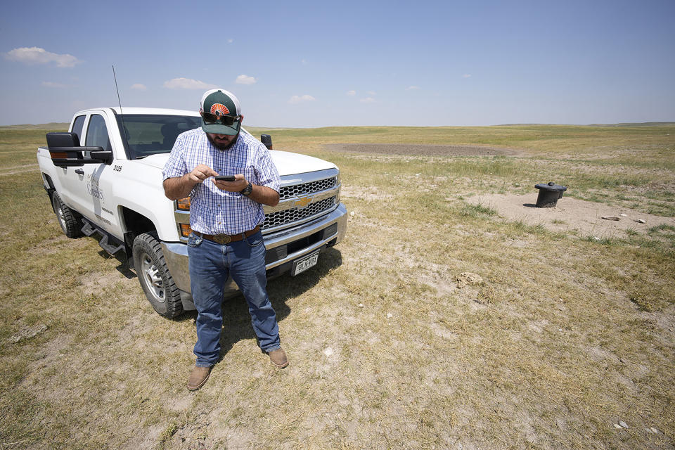 In this Monday, July 26, 2021, photograph, Cole Gustafson, water resource administrator for the Greeley, Colo., Water Department, uses his mobile telephone to locate a well head on the Terry Bison Ranch near Carr, Colo. Figures released this month show that population growth continues unabated in the South and West, even as temperatures rise and droughts become more common. That in turn has set off a scramble of growing intensity in places like Greeley to find water for the current population, let alone those expected to arrive in coming years. (AP Photo/David Zalubowski)