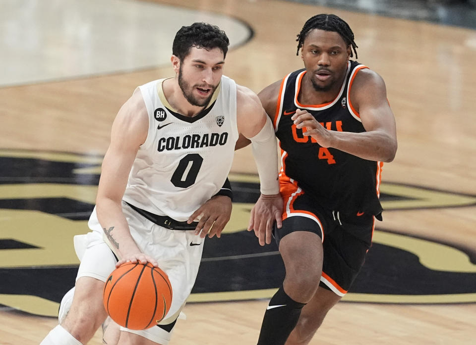 Colorado guard Luke O'Brien, left, drives past Oregon State guard Dexter Akanno, right, in the second half of an NCAA college basketball game Saturday, Jan. 20, 2024, in Boulder, Colo. (AP Photo/David Zalubowski)