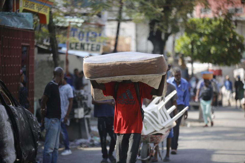 A man hauls a mattress as residents flee their homes due to gang violence in Port-au-Prince, Haiti, Thursday, March 7, 2024. (AP Photo/Odelyn Joseph)
