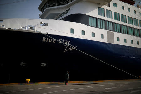 A man jogs next to a moored passenger ferry during a 24-hour strike of Greece's seamen's federation PNO, at the port of Piraeus, Greece, April 18, 2018. REUTERS/Alkis Konstantinidis