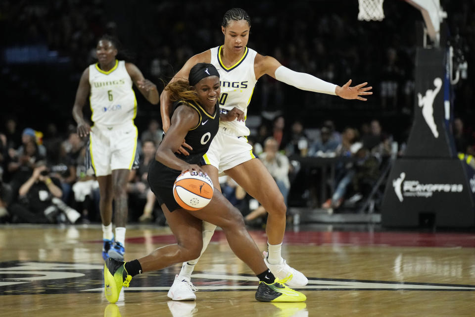 Dallas Wings forward Satou Sabally, right, fouls Las Vegas Aces guard Jackie Young during the second half in Game 2 of a WNBA basketball semifinal series Tuesday, Sept. 26, 2023, in Las Vegas. (AP Photo/John Locher)