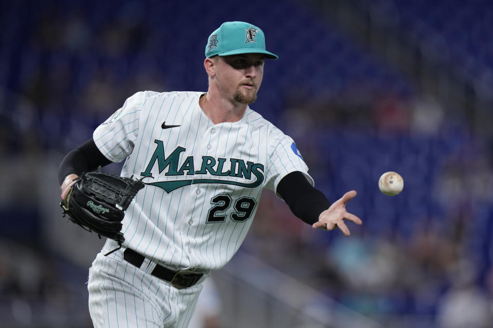 Miami Marlins starting pitcher Braxton Garrett tosses the ball to first to put out Washington Nationals' Keibert Ruiz as CJ Abrams scores during the first inning of a baseball game, Friday, Aug. 25, 2023, in Miami. (AP Photo/Wilfredo Lee)