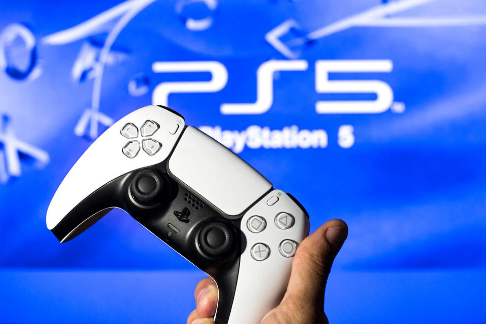 SPAIN - 2021/11/08: In this photo illustration, a PlayStation 5 controller seen with a PlayStation 5 logo in the background. (Photo Illustration by Thiago Prudencio/SOPA Images/LightRocket via Getty Images)