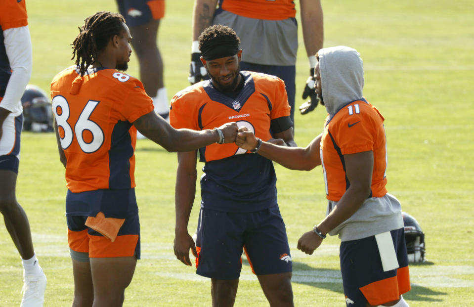 From left, Denver Broncos wide receivers Tyrie Cleveland, Kendall Hinton and Diontae Spencer greet each other before taking part in drills at the team's NFL football training camp Friday, Aug. 14, 2020, in Englewood, Colo. (AP Photo/David Zalubowski)