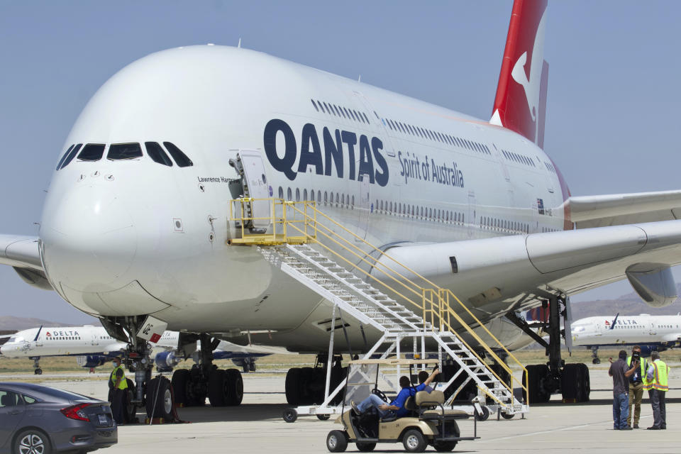 FILE - In this July 6, 2020, file photo, a Qantas Airbus A380 arrives at Southern California Logistics Airport in Victorville, Calif. Qantas Chief Executive Alan Joyce, Australia's largest airline, said that once a virus vaccine becomes widely available, his carrier will likely require passengers use it before they can travel abroad or land in Australia. (AP Photo/Matt Hartman, File)