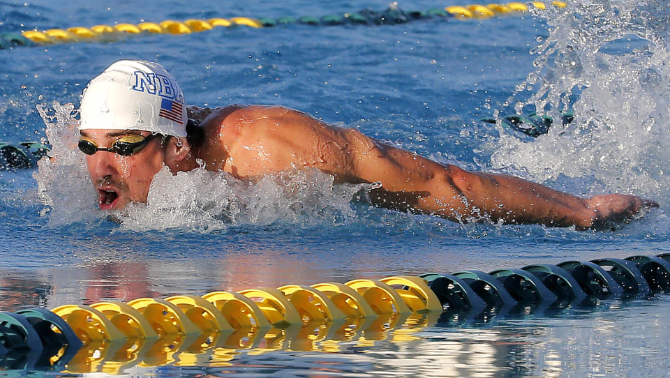 Michael Phelps competes in the 100-meter butterfly final during the Arena Grand Prix, Thursday, April 24, 2014, in Mesa, Ariz. Phelps was competing for the first time since the 2012 London Olympics. He finished second in the event. (AP Photo/Matt York)