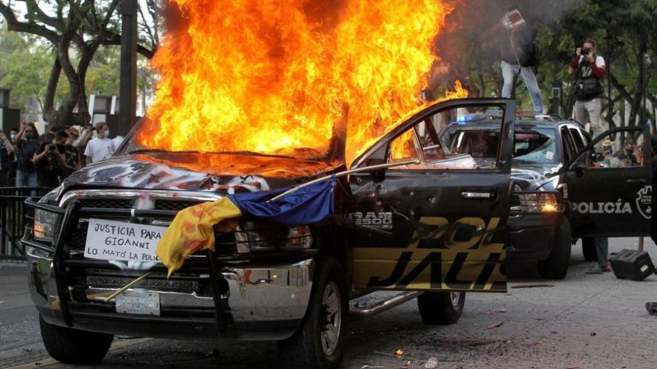 Auto ardiendo durante una protesta en Jalisco, Guadalajara, por la muerte de Giovanni López.