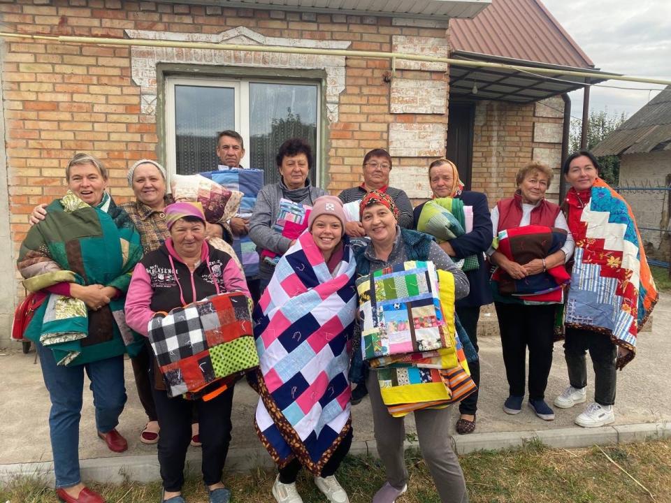 Recipients display their MCC comforters. MCC partner Association of Mennonite Brethren Churches of Ukraine (AMBCU) distributed MCC humanitarian assistance to socially and economically vulnerable people in the Zaporizhzhia region in October 2023.