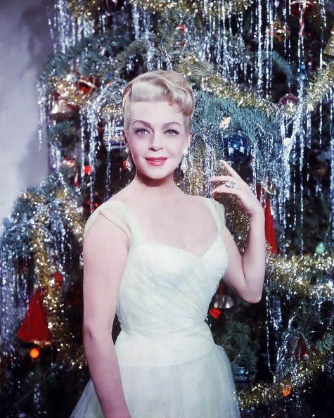 1955: Lana Turner poses with a tinseled tree