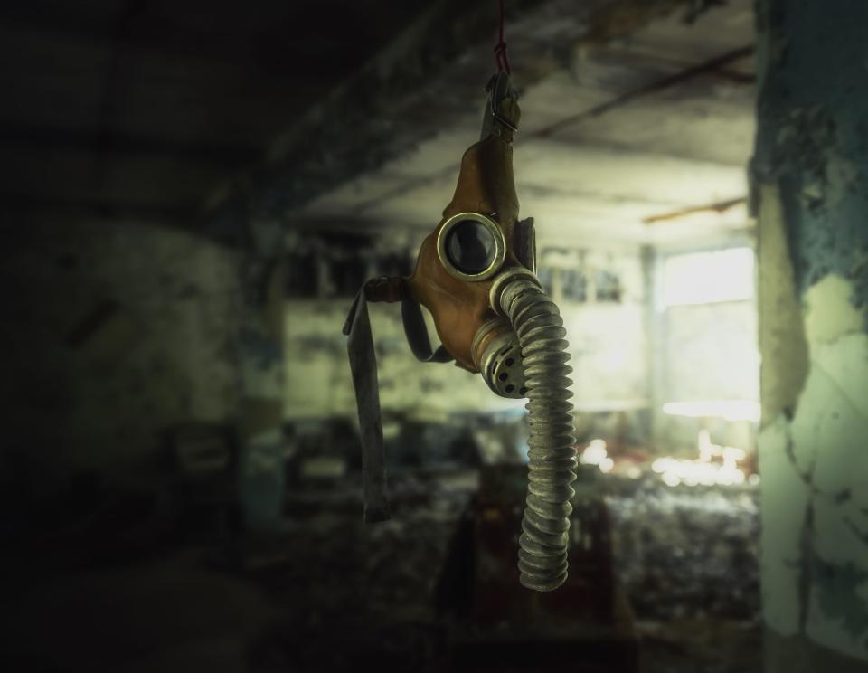 A single gas mask hangs from a hook