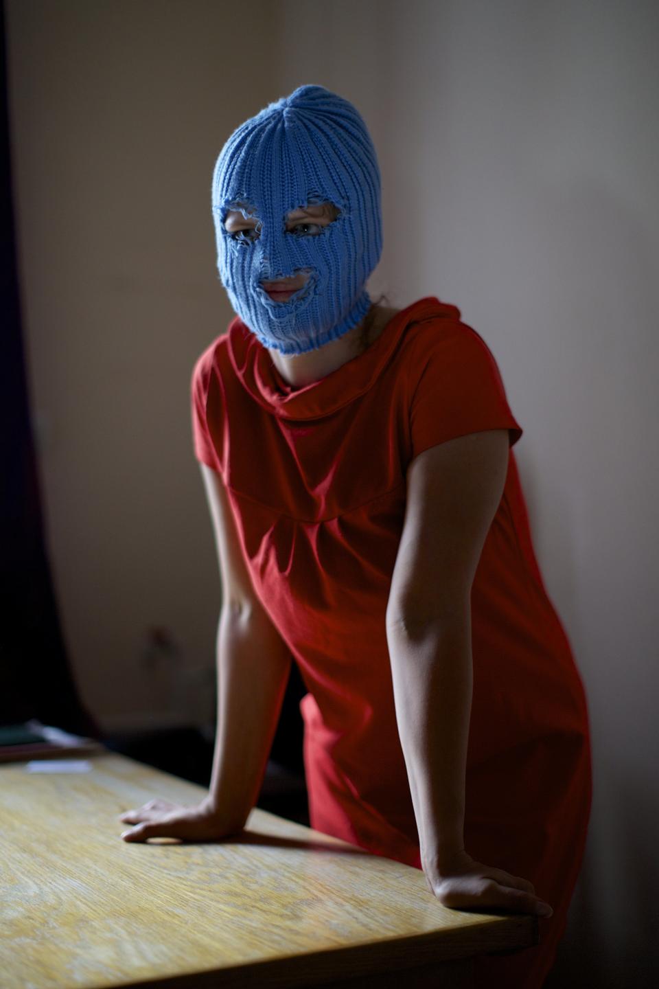 A member of Russian punk band Pussy Riot, who gave only her stage name of Grelka, wears a blue balaclava as speaks to the media in Moscow, Tuesday, July 16, 2013. Russian provocateurs Pussy Riot are back in action, releasing their first music video since three members went to prison last year for a prank denouncing Vladimir Putin. The video shows band members in trademark bright-colored balaclavas and short skirts, cavorting and shrieking atop an oil rig. Backed by hectic guitar and a drum fusillade, they pour oil on a large photo of state oil giant Rosneft’s chairman and liken Putin to an Iranian ayatollah. Pussy Riot member Grelka said after the video’s Tuesday release that “the main message is that Putin has spread the country’s wealth among his friends.” (AP Photo/Alexander Zemlianichenko)