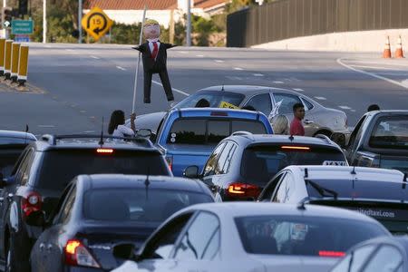 Protesters carry a pinata of Republican presidential candidate Donald Trump across the road outside the Luxe Hotel, where Trump expected to speak in Brentwood, Los Angeles, California, United States July 10, 2015. REUTERS/Lucy Nicholson