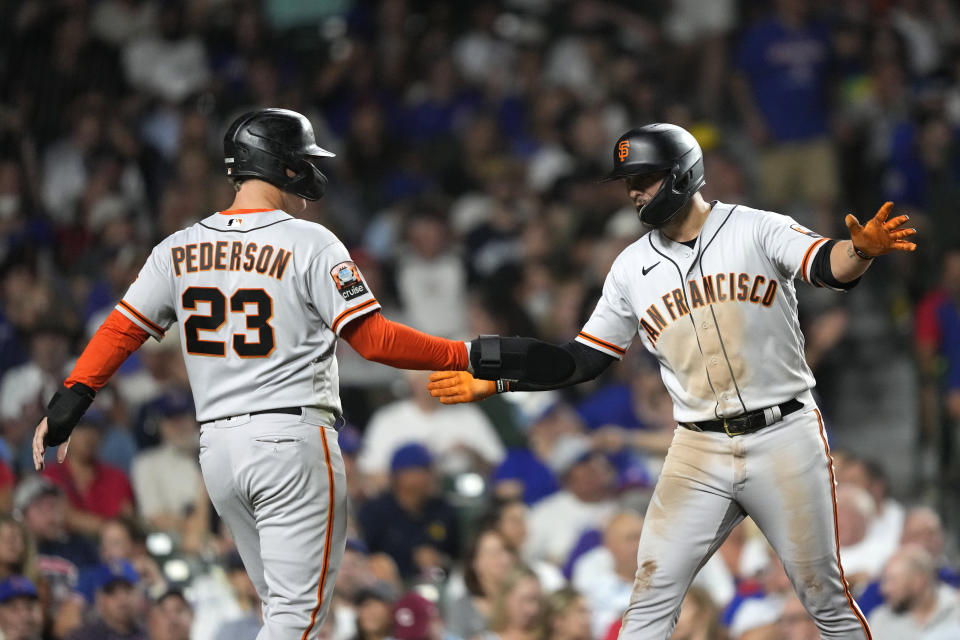 San Francisco Giants' Joc Pederson (23) greets J.D. Davis at home after they scored on Davis' two-run home run off Chicago Cubs relief pitcher Hayden Wesneski during the sixth inning of a baseball game Tuesday, Sept. 5, 2023, in Chicago. (AP Photo/Charles Rex Arbogast)