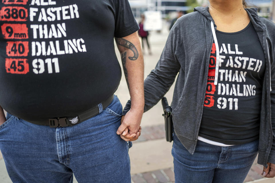 FILE - Albuquerque residents Michael Caldwell, left, and his wife, Natasha Caldwell, attend a Second Amendment Protest in response to Gov. Michelle Lujan Grisham's recent public health order suspending the conceal and open carry of guns in and around Albuquerque for 30-days, Tuesday, Sept. 12, 2023, in Albuquerque, N.M. Natasha said "we came to stand for the constitution and out of anger about what's happening with this health order." Restrictions on carrying guns in public that are tied to an emergency public health order are going under the legal microscope Tuesday, Oct. 3, in New Mexico. (AP Photo/Roberto E. Rosales, File)