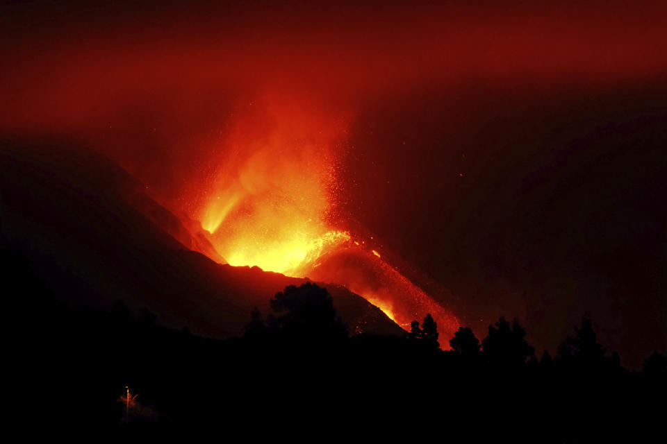 A view of the volcano continues to spew out lava on the Canary island of La Palma, Spain in the early hours of Sunday, Oct. 10, 2021. A new river of lava has belched out from the La Palma volcano, spreading more destruction on the Atlantic Ocean island where molten rock streams have already engulfed over 1,000 buildings. The partial collapse of the volcanic cone has sent a new lava stream heading toward the western shore of the island. (AP Photo/Daniel Roca)