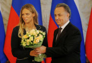 Russian Sports Minister Vitaly Mutko presents flowers to Olympic silver medalist Yulia Efimova during a meeting with Russian Olympic medallists returning home from the 2016 Rio Olympics, at the Kremlin in Moscow, Russia August 25, 2016. REUTERS/Maxim Shemetov