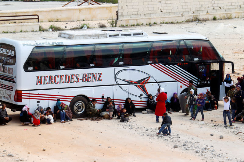 Des personnes évacuées des deux villages chiites rebelles d'al-Foua et Kefraya attendent de rejoindre Alep en bus. Les évacuations de populations de quatre zones assiégées de Syrie ont repris mercredi, quatre jours après un attentat à la bombe contre un convoi qui a fait 126 morts, dont une soixantaine d'enfants. /Photo prise le 19 avril 2017/REUTERS/Ammar Abdullah