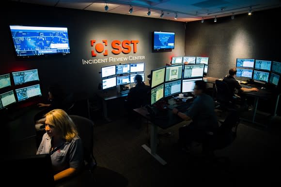 ShotSpotter's Incident Review Center, showing several employees at workstations equipped with several computer screens.