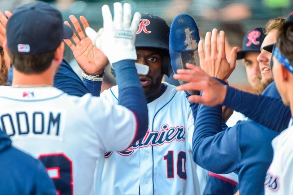 Tacoma Rainiers outfielder Taylor Trammell (10) gets high fives in the dugout after he scored on a Zach Green single in the top of the first inning of the season opener at Cheney Stadium in Tacoma, Wash., on Tuesday, April 5, 2022.