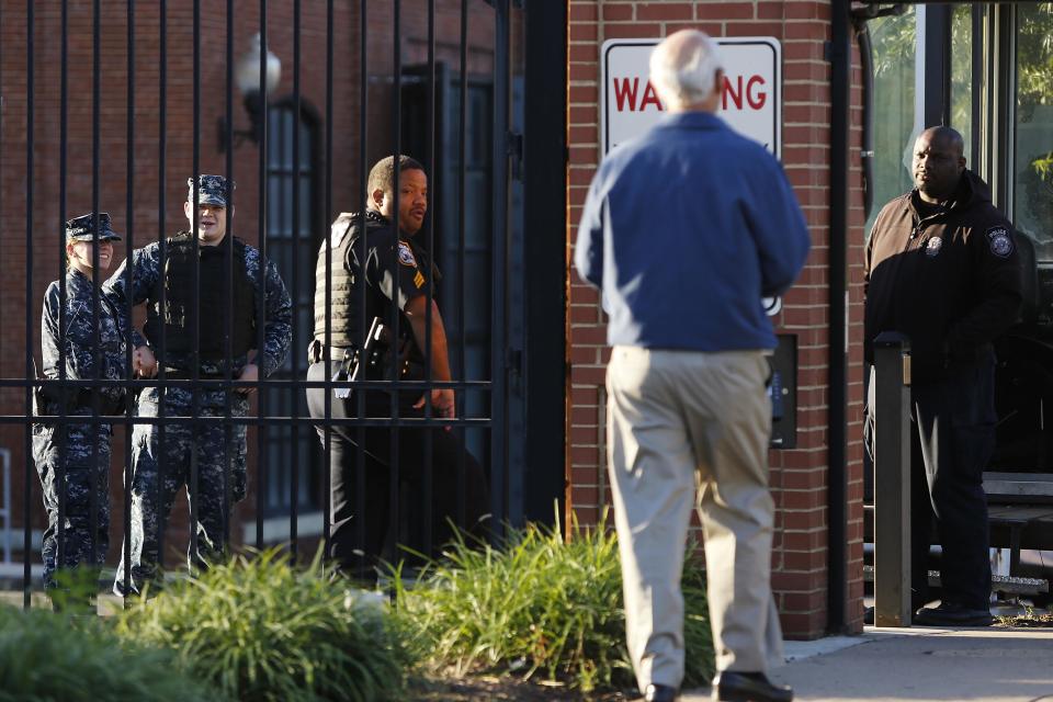 A Navy Yard personnel approaches a security checkpoint as he returns to work two days after a gunman killed 12 people before police shot him dead, in Washington, September 18, 2013. U.S. lawmakers are calling for a review into how Aaron Alexis, the suspected shooter in Monday's rampage at the Washington Navy Yard, received and maintained a security clearance, despite a history of violent episodes. REUTERS/Jonathan Ernst (UNITED STATES - Tags: MILITARY CRIME LAW)