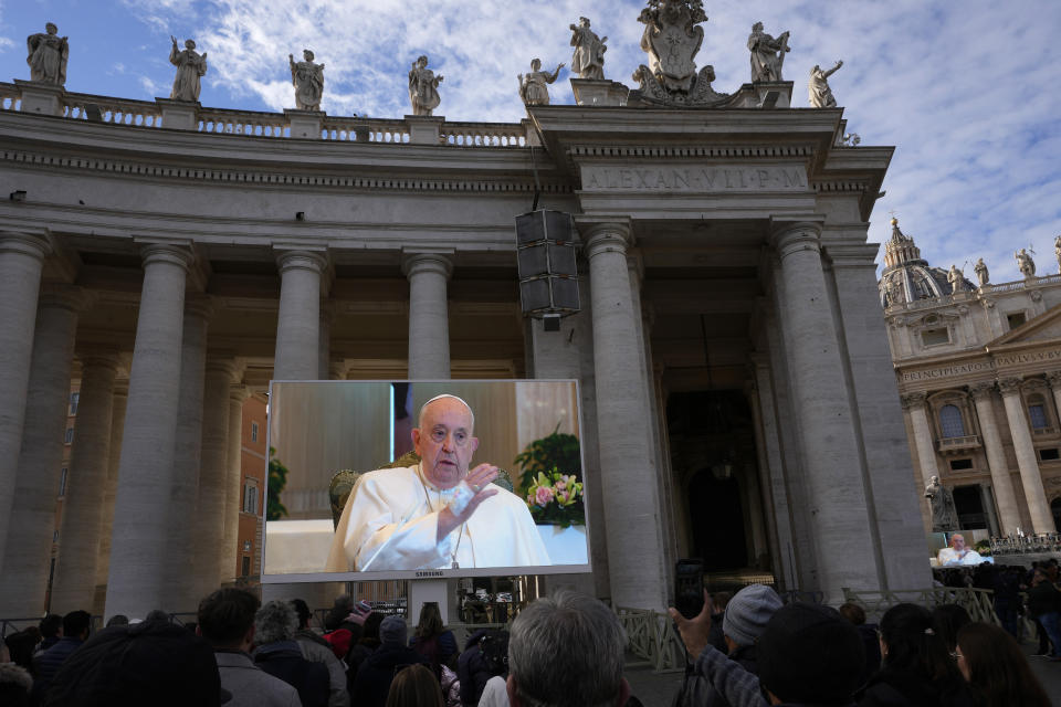 A giant screen broadcasts Pope Francis delivering his blessing during the Angelus noon prayer, from the chapel of the hotel at the Vatican grounds where he lives, Sunday, Nov. 26, 2023. Pope Francis says he has a lung inflammation but will go later this week to Dubai for the climate change conference. Francis skipped his weekly Sunday appearance at a window overlooking St. Peter's Square, a day after the Vatican said he was suffering from a mild flu. (AP Photo/Alessandra Tarantino)