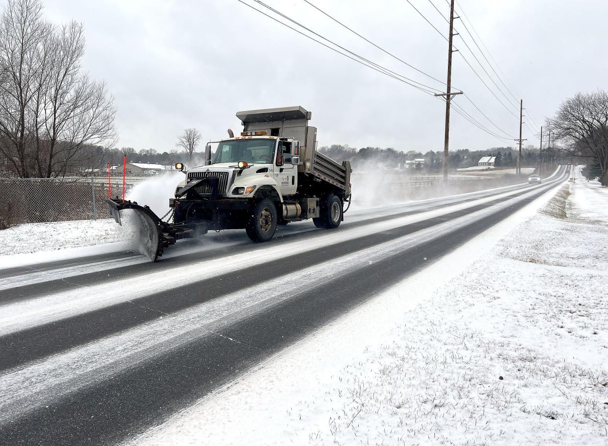 A Mansfield City snow plow driver clears Millsboro Road from overnight snowfall Saturday.
