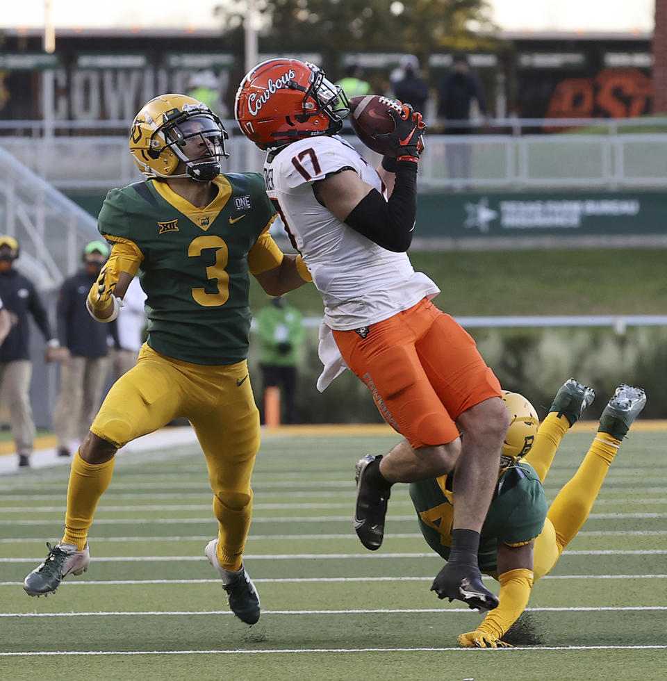 Oklahoma State wide receiver Dillon Stoner (17) catches a pass against Baylor cornerback Raleigh Texada (3) in the second half of an NCAA college football game, Saturday, Dec. 12, 2020, in Waco, Texas. (Jerry Larson/Waco Tribune-Herald via AP)