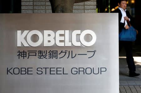 FILE PHOTO: A man walks past the signboard of Kobe Steel at the group's Tokyo headquarters in Tokyo, Japan October 10, 2017. REUTERS/Issei Kato/File Photo