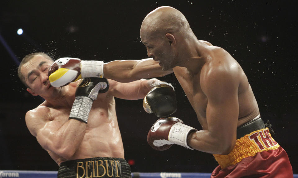 Beibut Shumenov, left, of Kazakhstan, takes a punch from Bernard Hopkins, right, of the United States, during their IBF, WBA and IBA Light Heavyweight World Championship unification boxing match, Saturday, April 19, 2014, in Washington. Hopkins won by a split decision. (AP Photo/Luis M. Alvarez)