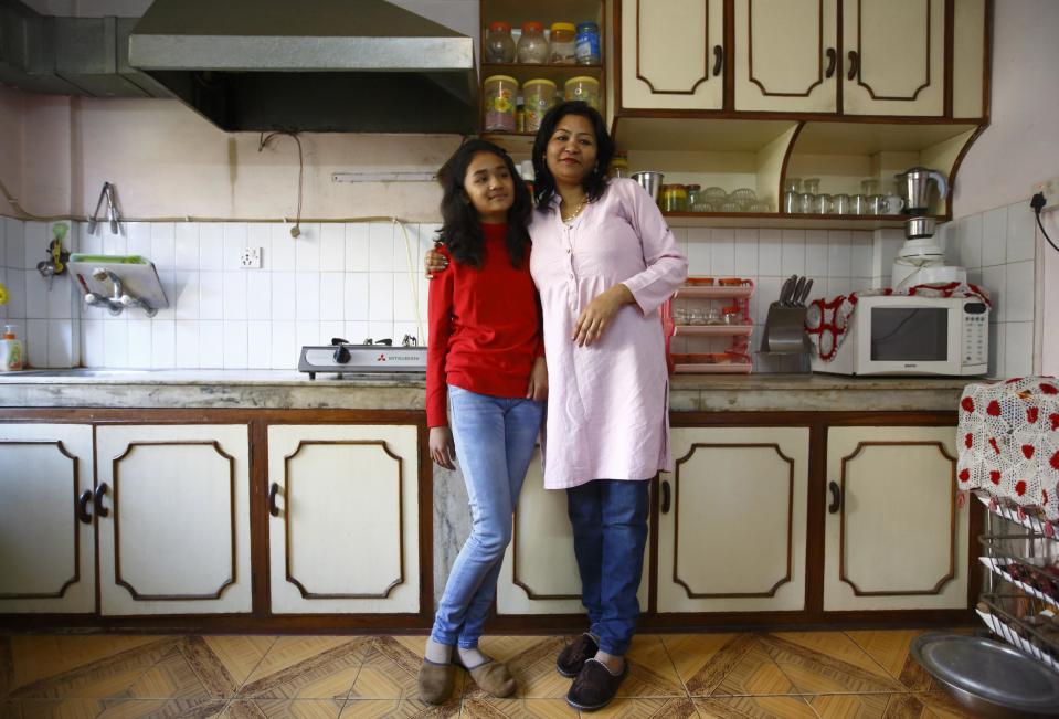 Mohanna Khanal and her daughter Vipassna Khanal pose for a photograph in the kitchen of their apartment in Kathmandu