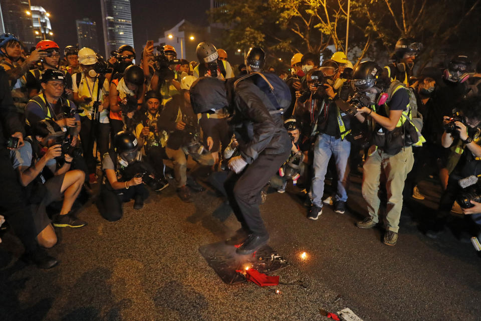 A black-clad protester wearing goggles and a mask stomps on a burning Chinese flag in Hong Kong, Sept. 28, 2019. (Photo: Vincent Thian/AP)