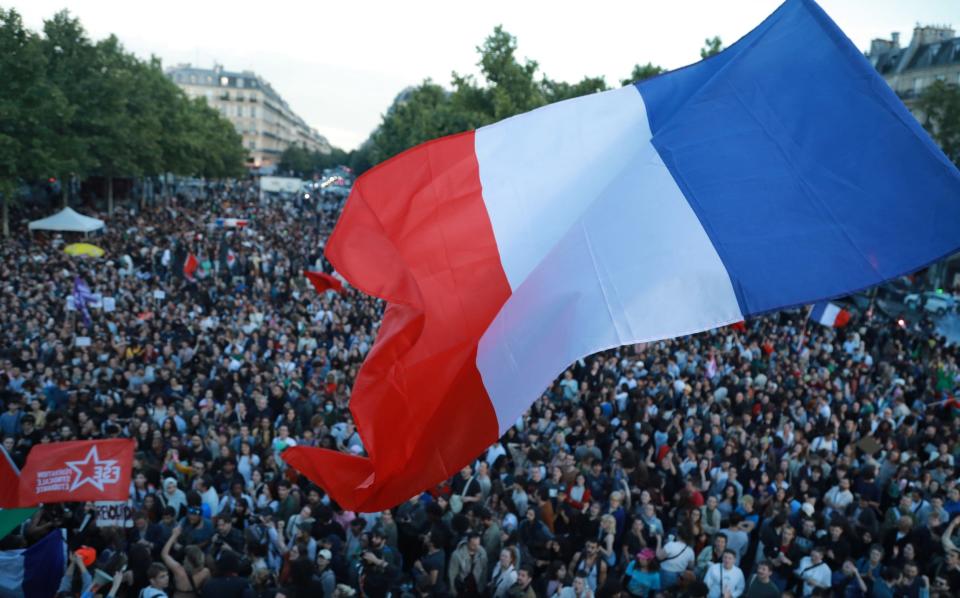 People, holding flags and banners, gather at the Republique Square in Paris