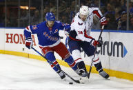 New York Rangers' Chris Kreider (20) and Washington Capitals' John Carlson (74) vie for the puck during the second period of an NHL hockey game Thursday, Feb. 24, 2022, in New York. (AP Photo/John Munson)