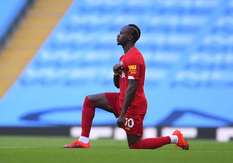 El atacante del Liverpool Sadio Mané se arrodilla en apoyo de la campaña Black Lives Matter antes del partido con el Manchester City por la Liga Premier, en el Etihad Stadium, en Manchester, Inglaterra