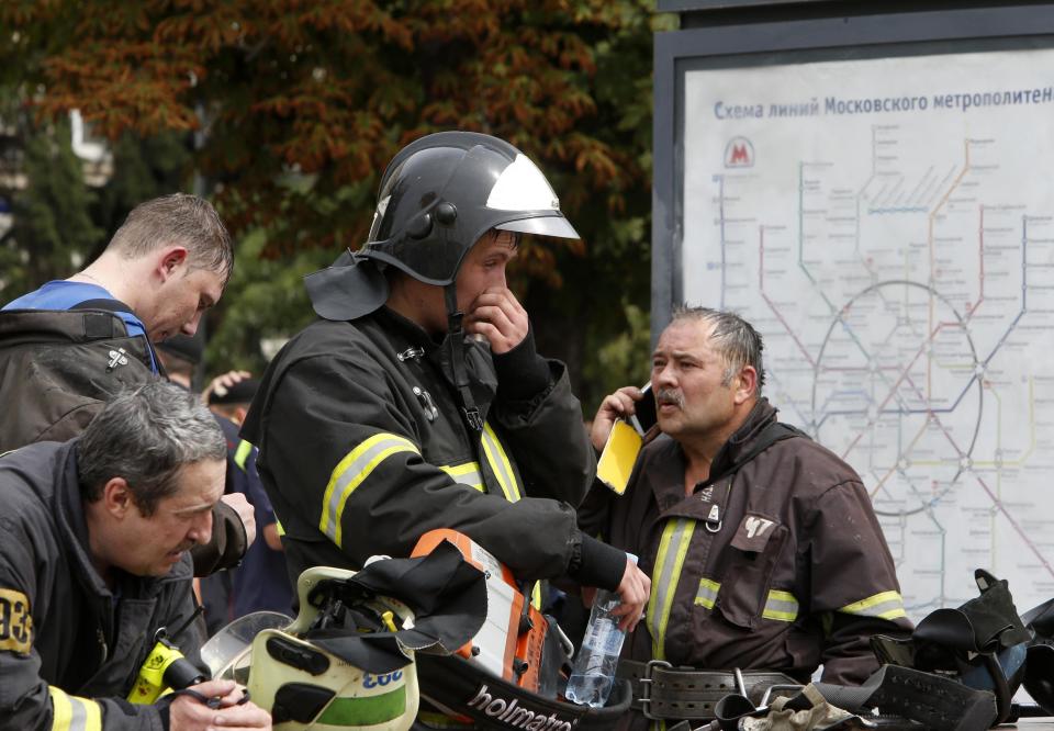 Members of the emergency services stand near a map of train lines outside a metro station following an accident on the subway in Moscow July 15, 2014. Five people were killed and nearly 100 were injured when an Moscow underground train went off the rails between two stations during the morning rush hour on Tuesday, the Health Ministry said. (REUTERS/Sergei Karpukhin)