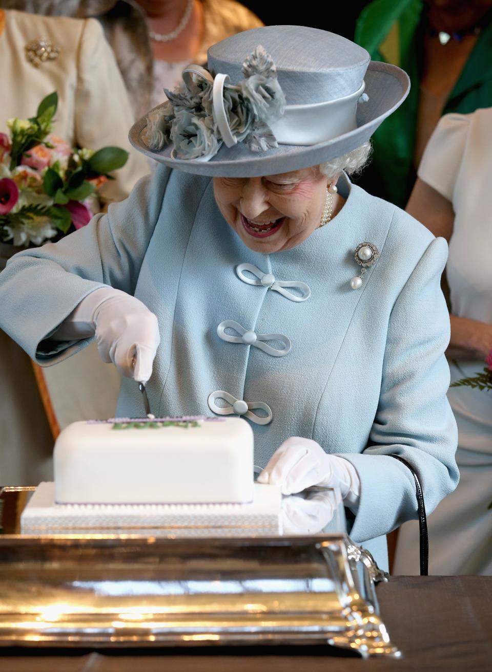 Queen Elizabeth cuts a cake