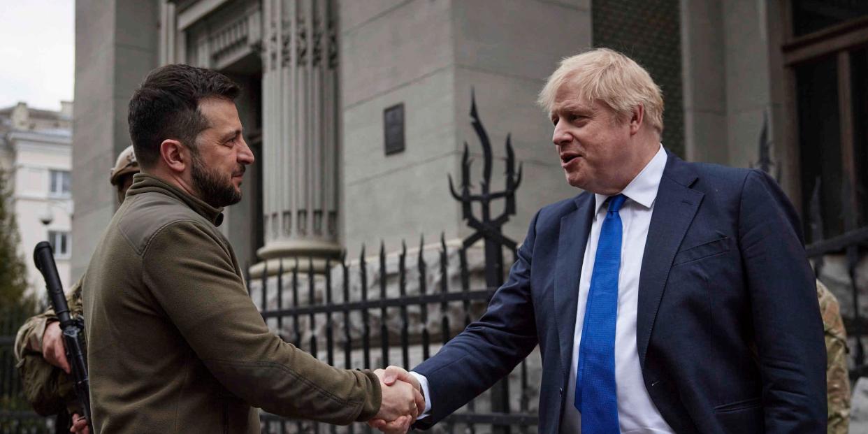 Ukrainian President Volodymyr Zelenskyy, left, and Britain's Prime Minister Boris Johnson, shake hands during their walk in downtown Kyiv, Ukraine, Saturday, April 9, 2022.