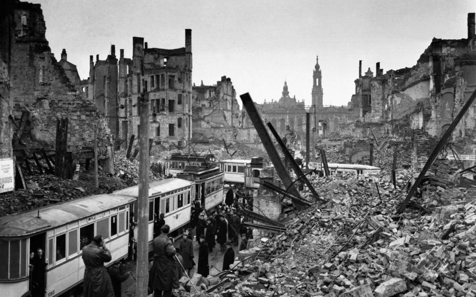 Citizens of Dresden in the Soviet part of Germany try to board trams amid the ruins and chaos