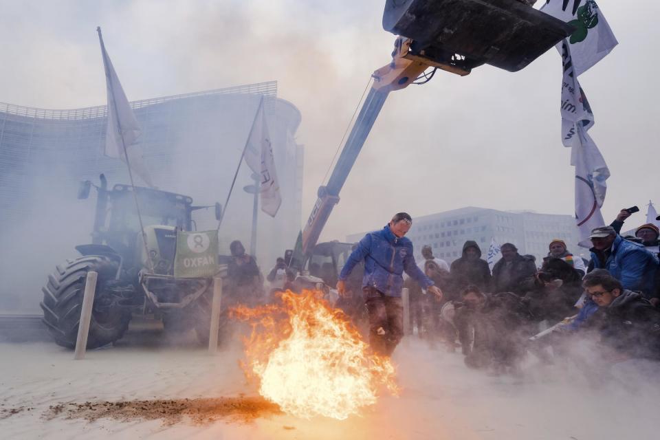 European dairy farmers burn milk powder during a protest at the EU Council building, in Brussels on Monday, Jan. 23, 2017. The sector has been hit with sagging prices and production costs squeezing profits to the extent that has driven many farmers to the brink of bankruptcy. The EU's executive Commission has approved some support measures over the past year, but the farmers fear that releasing more milk powder on the market would further complicate their plight. (AP Photo/Geert Vanden Wijngaert)