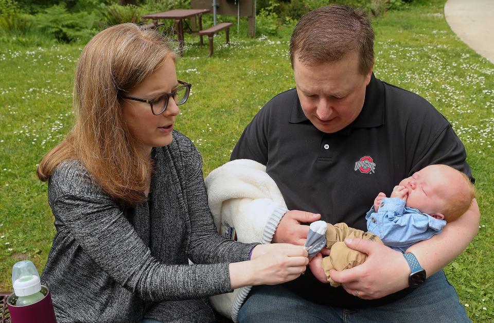 Leanne Wetzel puts on son Charlie's socks as she and husband Pete talk about Charlie's birth in the ferry lanes, at Bainbridge Island's Waterfront Park on May 19.