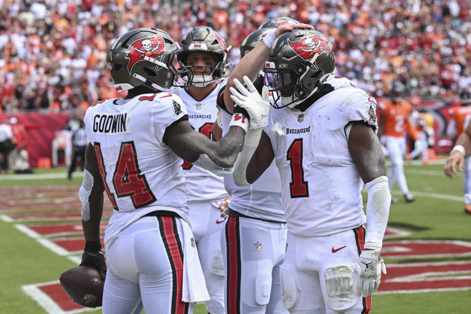 Tampa Bay Buccaneers wide receiver Chris Godwin, left, celebrates his touchdown catch against the Denver Broncos with teammates including running back Rachaad White (1) during the first half of an NFL football game, in Tampa, Fla. on Sunday, Sept. 22, 2024. (AP Photo/Jason Behnken)