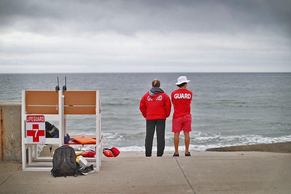 DCR lifeguards Megan Cormican, of Quincy, and Steven McDougall, of Hingham, scan a mostly empty Nantasket Beach on July 13 from the boardwalk. The state allocated $250,000 for emergency repairs to the boardwalk.