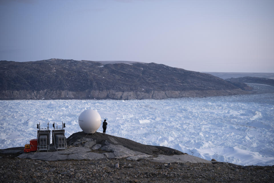 FILE - In this Aug. 16, 2019 file photo, a woman stands next to an antenna at an NYU base camp at the Helheim glacier in Greenland. According to a study released on Thursday, Aug. 20, 2020, Greenland lost a record amount of ice during an extra warm 2019, with the melt massive enough to cover California in more than four feet (1.25 meters) of water. (AP Photo/Felipe Dana)