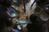 People prepare dozens of momos, traditional Tibetan steamed dumplings, in the garage of a home in Columbia Heights, Minn., on Monday, July 19, 2021. (AP Photo/Jessie Wardarski)