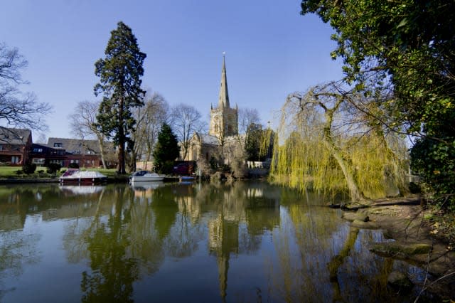 Holy Trinity Church is reflected in river Avon.