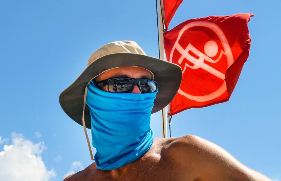 Palm Beach lifeguard George Klein wears a mask at Midtown Beach in Palm Beach that remains closed due to red tide warnings, Sunday, September 30, 2018. (Melanie Bell / The Palm Beach Post)