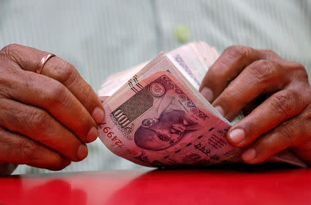 FILE PHOTO: A man counts Indian currency notes inside a shop in Mumbai, India, August 13, 2018. REUTERS/Francis Mascarenhas/File photo