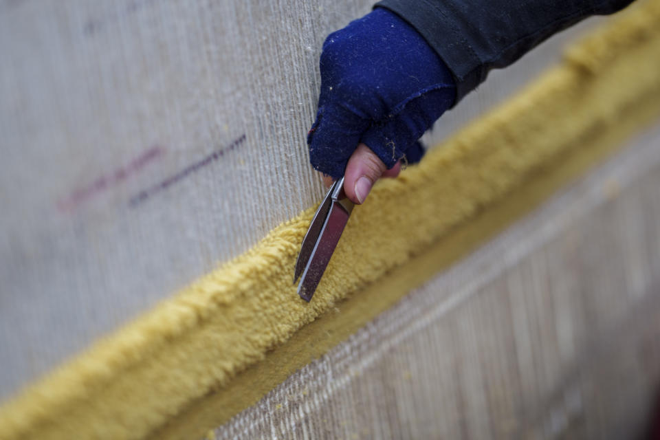 A craftswoman works on a tapestry at the Royal Tapestry Factory in Madrid, Spain, Friday, Nov. 30, 2023. Since its foundation in 1721, the Royal Tapestry Factory of Madrid has not stopped producing. It was Philip V, then King of Spain, who had the factory built with the help of Catholic craftsmen from Flanders to replace the lack of private initiative that existed at the time. (AP Photo/Manu Fernandez)