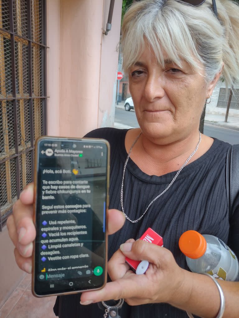 Silvina Palazzo, voluntaria del programa porteño Ayuda a Mayores, muestra la notificación de Boti para el barrio donde vive, Liniers